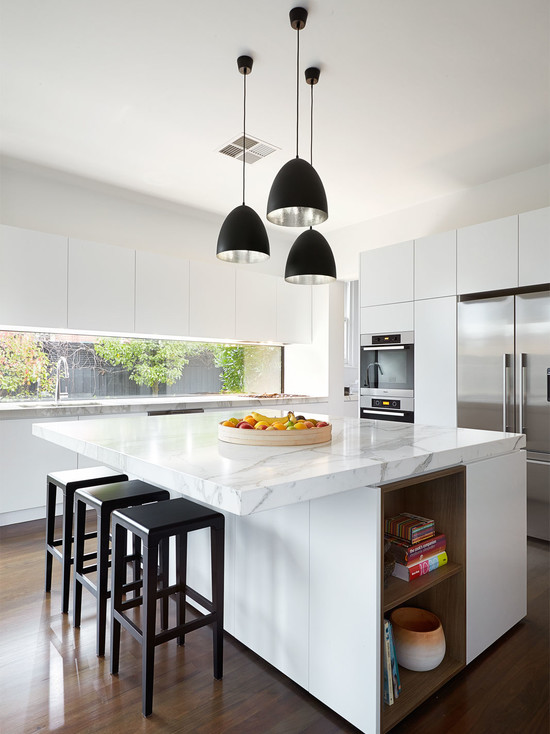Дизайн интерьера кухни в стиле минимализм: освещение обеденной зоны светильниками с контрастными чёрными плафонами