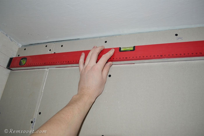 Разметка под направляющий профиль для подвесного потолка с помощь строительного уровня